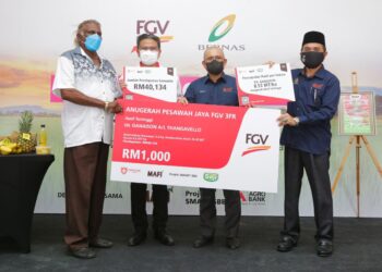 RONALD KIANDEE (dua kanan) menyerahkan replika cek kepada T. Ganaison (kiri) yang menerima Anugerah Pesawah Jaya FGV 3FR Hasil Tertinggi di Kilang Beras Bernas Seri Tiram Jaya, Tanjong Karang di Kuala Selangor, Selangor, semalam.