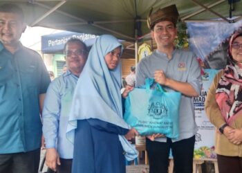 MOHAMMED Taufiq Johari (dua dari kanan) menyampaikan sumbangan kepada seorang pelajar, Ina Zainal sempena Program Jualan Syawal Madani 1444H di Pasar Tani Jalan Petri, Sungai Petani, Kedah, baru-baru ini. - UTUSAN/ABD RAZAK OSMAN