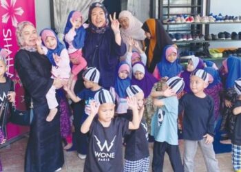 AZURA Mokhtar (kiri, mendukung kanak-kanak) bergambar bersama penghuni Rumah Amal Al Firdaus Denai Alam Bukit Jelutong, Shah Alam, semalam. – FOTO/ABDUL RAZAK IDRIS
