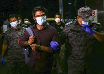 MD. Rayhan Kabir diiring anggota Jabatan Imigresen untuk dihantar pulang ke negara asalnya di Lapangan Terbang Antrabangsa Kuala Lumpur (KLIA) malam tadi. - UTUSAN/FAISOL MUSTAFA