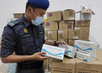 PENGUAT KUASA KPDNHEP menyerbu sebuah premis membungkus semula sarung tangan getah tiruan menggunakan jenama Max Care di Seri Kembangan, Selangor semalam.