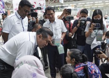 ANTHONY Loke Siew Fook beramah mesra dengan penumpang kanak-kanak selepas mengedarkan pek hari raya kepada penumpang tren yang pulang ke kampung halaman sempena cuti Hari Raya Aidilfitri 2023 di Stesen Sentral Kuala Lumpur, hari ini. Turut mengiringi Ketua Pegawai Eksekutif KTMB, Datuk Mohd. Rani Hisham Samsudin (tengah). - FOTO/MUHAMAD IQBAL ROSLI