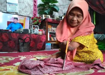 FATIMAH Daud menunjukkan kemahiran menggunting kain milik pelanggan sebelum di jahit di Kampung Pelekbang, Tumpat, Kelantan hari ini-UTUSAN/ROHANA ISMAIL