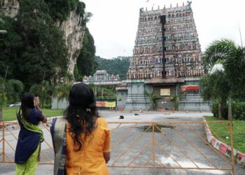 S. PANIMALAR (kiri) bersama adiknya melakukan upacara keagamaan sempena sambutan Thaipusam  di luar pekarangan Kuil Sri Subramaniar di  Ipoh, Perak, semalam. – UTUSAN/ZULFACHRI ZULKIFLI