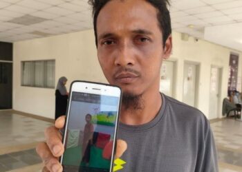 SUHAIMI Hassan menunjukkan gambar Muhammad Khairul Muhaimin yang meninggal dunia dalam kemalangan di Sungai Korok, Jitra, Kubang Pasu, Kedah. - UTUSAN/MOHD RAFIE AZIMI