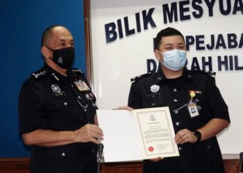 MIOR Faridalathrash Wahid (kiri) menyampaikan sijil penghargaan kepada Inspektor Tie Ngie Sieng di IPD Hilir Perak, Teluk Intan, hari ini. - FOTO/ZULFACHRI ZULKIFLI