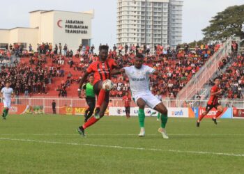 NUHA Krubally (kiri) cuba melepasi kawalan pertahanan Kuching City pada aksi Liga Super di Stadium Sultan Muhammad IV, Kota Bharu, Kelantan sebentar tadi.-UTUSAN/KAMARUL BISMI KAMARUZAMAN