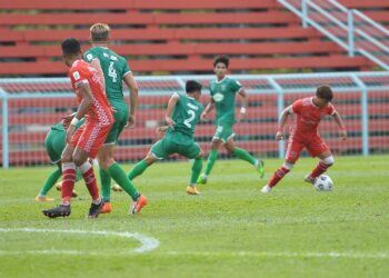 PEMAIN Kuching City (baju hijau) ketika menentang Kelantan FC dalam aksi Liga Perdana hari ini.