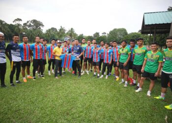 WAKIL PUC Sport ( kiri) menyampaikan sumbangan jersi terakhir kepada pasukan Kelantandi Padang Mardi Pasir Tumboh, Kota Bharu semalam. - UTUSAN/ZULHANIFA SIDEK