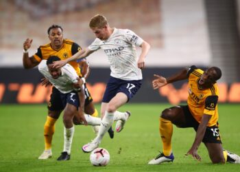 KEVIN de Bruyne (tengah) melepasi halangan pertahanan Wolverhampton, Willy Boly (kanan) dalam aksi Liga Perdana Inggeris di Stadium Molineux, Wolverhampton awal pagi tadi. - AFP