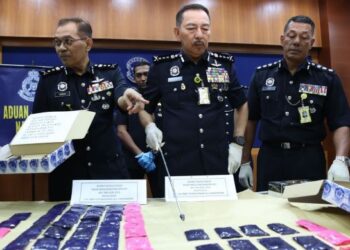 MUHAMAD Zaki Harun (tengah) menunjukkan pil yaba yang dirampas pihaknya semasa sidang media di Ibu Pejabat Polis Kontinjen (IPK) Kelantan, Kota Bharu, Kelantan, semalam. - FOTO/KAMARUL BISMI KAMARUZAMAN