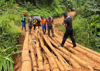 AB. Aziz Yusoff (dua dari kanan) meninjau jambatan kayu yang perlu dinaik taraf berhampiran Kampung Kajang, Pos Gob, Gua Musang, Kelantan. - FOTO/AIMUNI TUAN LAH