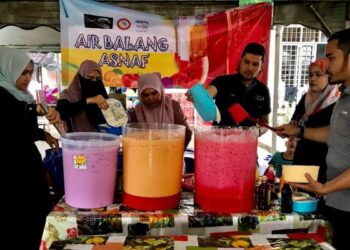 MAJIDAH Ismail (tengah) bersama Zurawati Zulkifli (dua dari kiri) dan Pengarah Urusan Beauty Kaseh, Mohd. Faizul Rohban Ahmad (tiga dari kanan) menyediakan air untuk diagihkan kepada asnaf di Tanjung Mas, Kota Bharu Kelantan, semalam. - FOTO/ROSLIZA MOHAMED