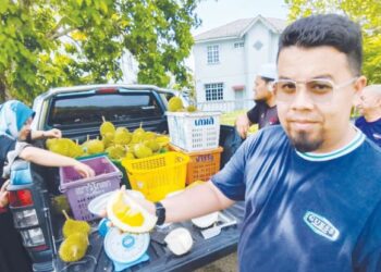 AHMAD Maher Safiain menunjukkan isi durian Musang King yang dijualnya di belakang Masjid Sultan Ismail Petra, Bandar Kubang Kerian, Kota Bharu, Kelantan. - UTUSAN/YATIMIN ABDULLAH