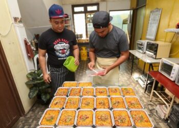CHE Ahmad Jauhari (kiri) dan Zamri Che Seman menyiapkan makaroni bakar yang dihasilkan mereka untuk dijual di bazar Ramadan sekitar Kota Bharu, Kelantan. - FOTO/ROHANA MOHD. NAWI