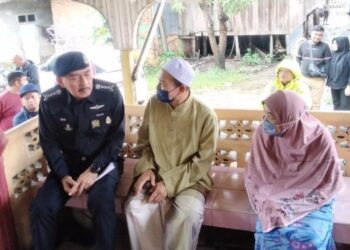 MUHAMAD Zaki Harun (kiri) semasa menziarahi bapa dan ibu kepada tiga beradik yang maut terkena renjatan elektrik di Kampung Morak, Tumpat, Kelantan, hari ini. - FOTO/ROHANA MOHD. NAWI