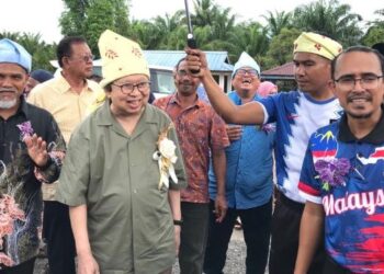 TENGKU Razaleigh Hamzah (dua dari kiri) tiba di SK Aring untuk Program Mengacau Bubur Asyura Merdeka di Felda Aring 1, Gua Musang, Kelantan. - FOTO/AIMUNI TUAN LAH