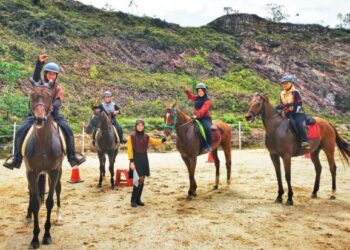 JALIJAH Awang Kenit (berdiri) sentiasa menemani dan memberi tunjuk ajar cara pengendalian kuda kepada pengunjung yang datang ke kandangnya di Bukit Sentosa, Rawang, Selangor. - FOTO/MOHAMAD HAFIZ YUSOFF BAKRI