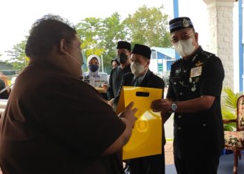 SHAFIEN Mamat menyampaikan kotak rezeki kurniaan Istana Mahkota Kelantan kepada para penerima di IPD Pasir Mas, Kelantan hari ini. - UTUSAN/YATIMIN ABDULLAH