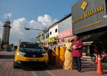 MOHD. Shaiful Hasri Shukri (kanan) bersama warga kedai emas Hajjah Halijah mengagihkan bubur lambuk yang menjadi tradisi setiap Ramadan sejak 10 tahun lepas kepada orang ramai di Sungai Petani. – UTUSAN/SHAHIR NOORDIN