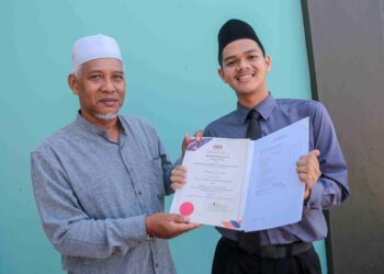 MUHAMMAD Syamil Kamarul Zaman menunjukkan slip SPM yang mencatat keputusan 11A+, 1A kepada bapanya, Kamarul Zaman Bakar pada Majlis Pengumuman Keputusan SPM 2022 Negeri Kedah di Sekolah Menengah Sains Sultan Mohamad Jiwa, Sungai Petani. – UTUSAN/ SHAHIR NOORDIN