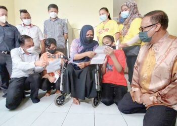 SOON Lip Chee (duduk, kiri) dan Lisa (tengah) masing-masing meneliti surat tawaran yang diberikan kepada Yumn Nakyeishaa dan Dahnea Dabryshaa di Pangsapuri Melur, Bagan Jermal, Pulau Pinang semalam.