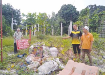 RAMLI Hamat (kiri) bersama Wan Mohd. Nasir (kanan) dan Pawira Mat Salleh menunjukkan bahan binaan terbiar sementara cerucuk tiang dewan serba guna dipenuhi semak-samun di Felda Kota Gelanggi Empat di Jerantut, Pahang. – UTUSAN/HARIS FADILAH AHMAD.