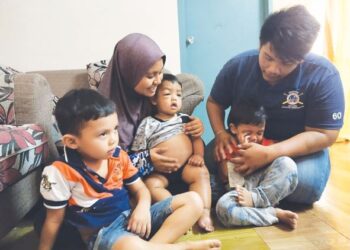 NOOR Athirah Abdullah memangku anaknya Muhammad Aqil sambil diperhatikan Mohd. Ashraf dan anak-anak mereka yang lain ketika ditemui semalam. – UTUSAN/NOR SHAFAWAYI YUP.