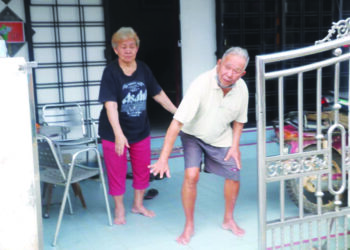 KUM Koh Leong (kanan) dan Kok Moi menunjukkan paras air banjir kilat yang melanda kediaman mereka Ahad lalu di Kampung Bukit Tinggi di Bentong, Pahang. – UTUSAN/SALEHUDIN MAT RASAD