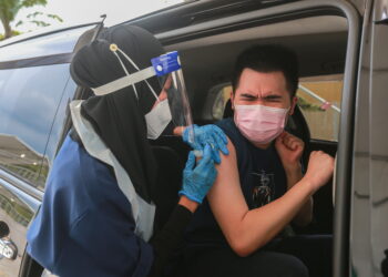 PETUGAS kesihatan  Ramsay Sime Darby Hospital memberi suntikan vaksin Covid-19 di Pusat Pemberian Vaksin (PPV) secara pandu lalu di Menara Sime Darby Plantation, Kuala Lumpur. – UTUSAN/AFIQ RAZALI