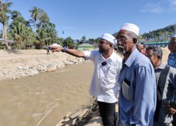 ABDUL Azeez Abdul Rahim (kiri) bersama penduduk memeriksa keadaan Sungai Kupang yang terjejas akibat kepala air dan banjir lumpur di Kupang, Baling, Kedah. -UTUSAN/NORLIA RAMLI
