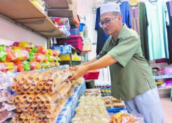 MOHAMAD Ali menyusun barang jualan di gerainya di Medan Samudera, Bandar Hilir, Melaka.
