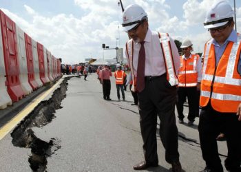 TAJUDDIN ABDUL RAHMAN (tengah) meninjau lokasi mendapan tanah di persimpangan Jalan Johan Setia dan Jalan Langat, Klang, Selangor.