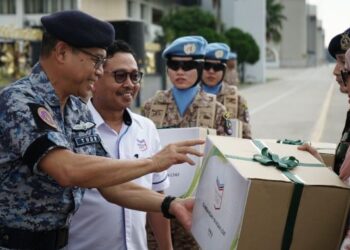 YAZID Arshad dan Mohd. Nizar Sudin (dari kiri) menyerahkan sumbangan kebajikan YLTAT kepada pasangan anggota yang menyertai misi MALBATT 850-10.