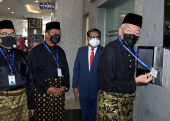 MAHDZIR Khalid mengimbas kad penanda waktu di Kementerian Pembangunan Luar Bandar bagi memulakan tugas hari pertamanya. - IHSAN KPLB