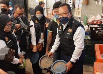 RUSDI Abd. Rahman (kanan) menunjukkan tudung jeruk sayur yang kotor di sebuah pasar raya di Malim, Melaka. - UTUSAN/AMRAN MULUP
