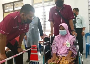 Dr Mansor Ismail (kiri) bertanyakan keadaan Sepora Amin, 106 (duduk) semasa Program Outreach Imunisasi Covid-19 di Pulau Tuba baru-baru ini.