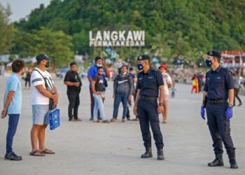 ANGGOTA polis melakukan pemantauan pematuhan prosedur operasi standard dalam kalangan pelancong di Pantai Chenang, Langkawi. – UTUSAN/ SHAHIR NOORDIN