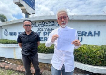 RAJA Kamarul Bahrin Shah Raja Ahmad (kanan) menunjukkan salinan laporan polis 
berhubung kenyataan Abdul Hadi Awang menyanggah titah Sultan Terengganu di Kuala Terengganu, hari ini.