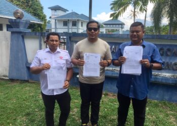 MOHD. Hafiz Aziz (tengah) menunjukkan laporan polis berhubung kenyataan fitnah dibuat di akaun Facebook palsu menggunakan nama Ahmad Razif Abdul Rahman di Balai Polis Gong Badak, Kuala Nerus, Terengganu hari ini.