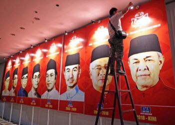 Seorang juruelektrik memasang lampu pada gambar-gambar Presiden UMNO sebagai persiapan menjelang Perhimpunan Agung UMNO (PAU) 2021 di Dewan Merdeka, Pusat Dagangan Dunia (WTC), semalam. -UTUSAN/ MUHAMAD IQBAL ROSLI