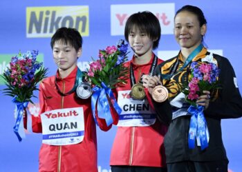 PANDELELA Rinong )(kanan) bersama dua penerjun China, Chen Yuxi (tengah) dan Quan Hongchan yang masing-masing memenangi emas dan perak.