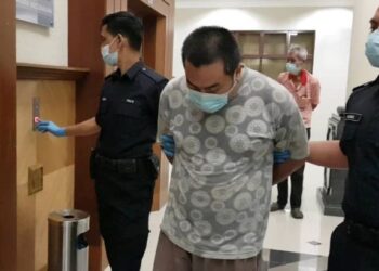 LIM Ming Soon dibawa keluar dari Mahkamah Sesyen Kuantan selepas dijatuhkan hukuman penjara enam tahun dan denda RM10,000 kerana memiliki bahan lucah kanak-kanak. - MOHD. SHAHRULANOOR ISHAK