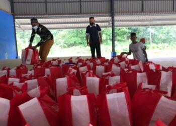 MAIK mengagihkan bakul makanan kepada masyarakat Orang Asli di Kampung Kuala Koh, Gua Musang, Kelantan, hari ini. - FOTO/AIMUNI TUAN LAH