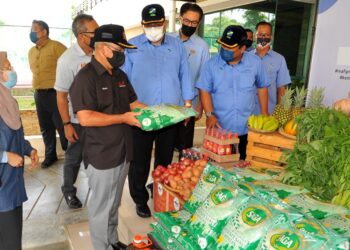 RONALD Kiandee (dua dari kiri) melihat produk makanan keluaran FAMA sempena lawatan kerja bagi tinjauan Aktiviti Rantaian Pengeksportan Produk Pertanian Segar Malaysia ke Singapura di Pejabat FAMA, Johor Bahru di Johor. -UTUSAN/RAJA JAAFAR ALI