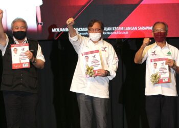 ABANG Johari Tun Openg (tengah ) menunjukan Buku Manifesto GPS bertempat di Borneo Convention Canter Kuching, Sarawak, malam ini. - UTUSAN/HARITH AUFA