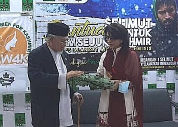 MOHD. Azmi Abdul Hamid ( kiri) menyampaikan selimut kepada Amna Baloch  sebagai simbolik pelancaran Bantuan Musim Sejuk Untuk Kashmir di Pejabat Mapim , Bukit Jelutong Selangor, baru-baru ini. - UTUSAN/ABDUL RAZAK IDRIS