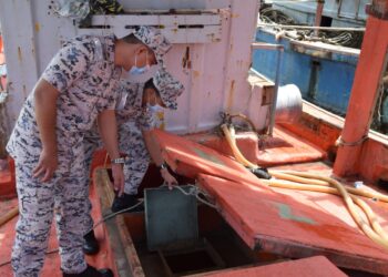 RASHIDILHADI Abd. Rashid (kiri) memeriksa bot nelayan Vietnam yang ditahan di kedudukan 58 batu nautika timur laut Kuala Kemaman di Kemaman kerana menceroboh perairan negara.m - UTUSAN/NIK NUR IZZATUL HAZWANI NIK ADNAN
