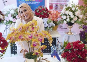 MASAYU Ismail bersama sebahagian gubahan bunga yang dihasilkannya.