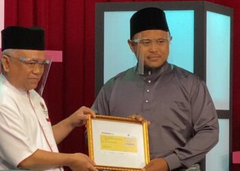 ABDUL AZIZ Jusoh (kiri) menyampaikan hadiah kepada Mohamad Fida’iy Zainal Abidin di Pusat Penyiaran AlHijrah, Kuala Lumpur hari ini.